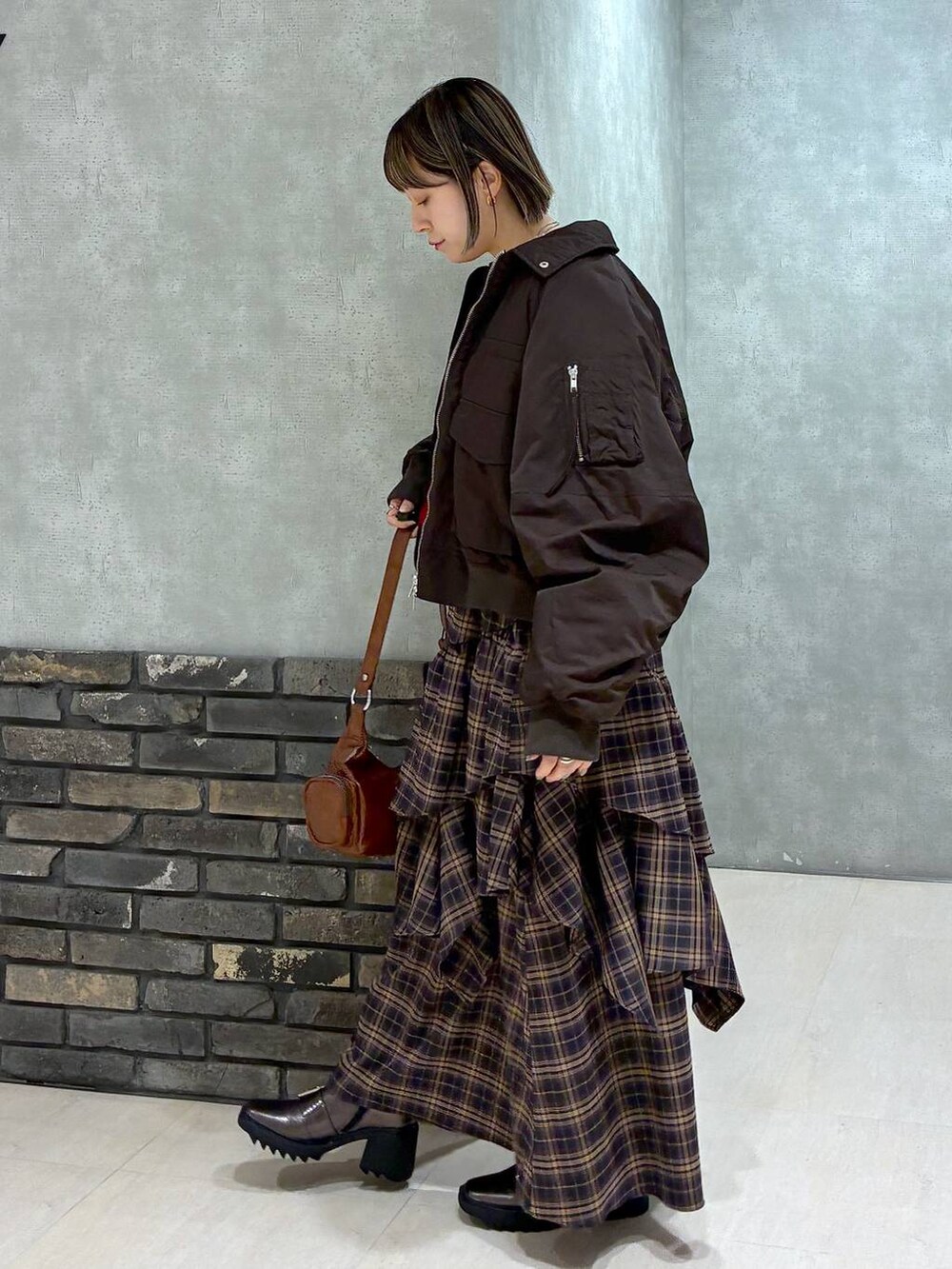 その他のブーツ、ブラウン系のスカート、ブラウン系のショルダーバッグを着用したレディースの冬コーディネートの7枚目の写真