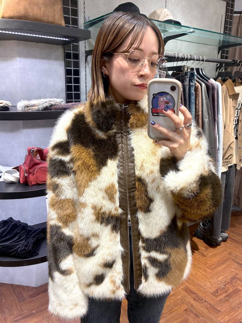 ブラック系のスニーカー、ブルー系のデニムパンツ、ブラウン系のブルゾンを着用したレディースの秋コーディネートの2枚目の写真