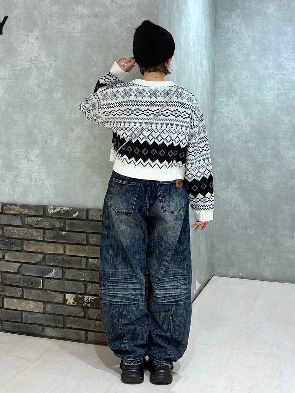 ブラック系のスニーカー、ブルー系のデニムパンツ、レッド系のハンドバッグを着用したレディースの秋コーディネートの3枚目の写真