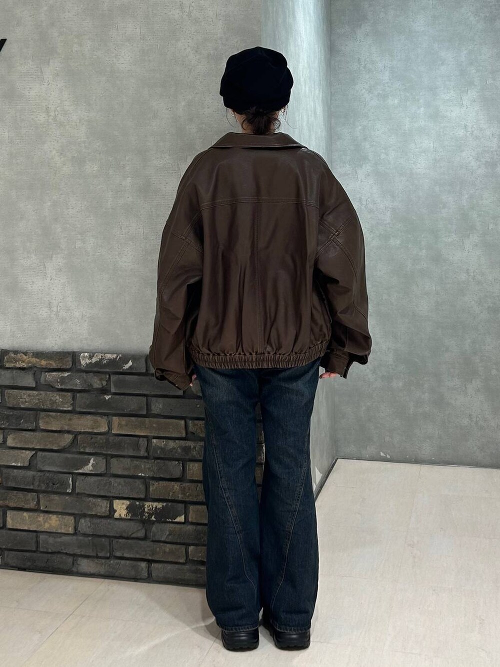 グレー系のスニーカー、ブルー系のデニムパンツ、ブラック系のTシャツ/カットソーを着用したレディースの秋コーディネートの4枚目の写真