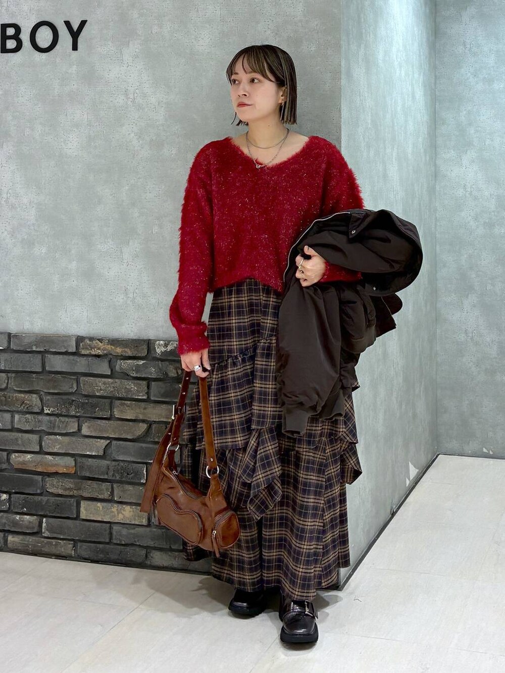 その他のブーツ、ブラウン系のスカート、ブラウン系のショルダーバッグを着用したレディースの冬コーディネートの3枚目の写真