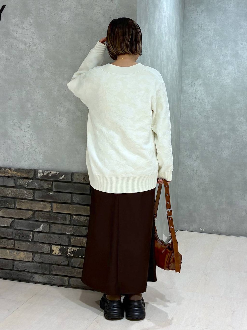 ブラウン系のブーツ、ブラウン系のニット/セーター、ブラウン系のスカートを着用したレディースの冬コーディネートの4枚目の写真