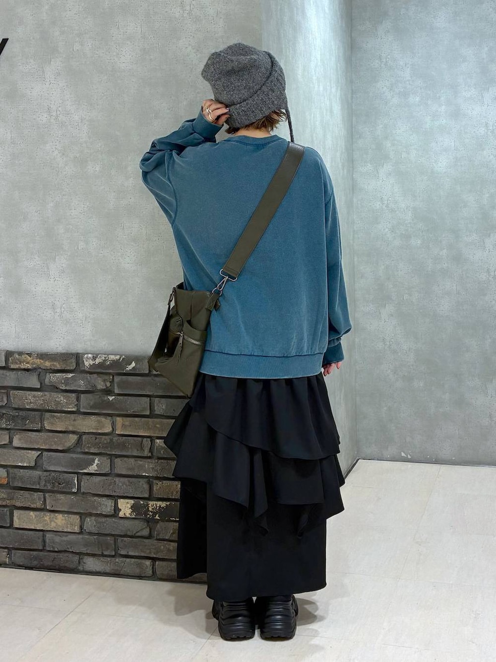 ブラック系のスニーカー、グリーン系のボストンバッグ、グリーン系のスウェットを着用したレディースの冬コーディネートの5枚目の写真