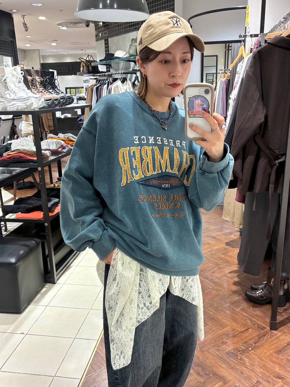 ブラック系のスニーカー、グリーン系のスウェット、ブルー系のデニムパンツを着用したレディースの秋コーディネートの2枚目の写真