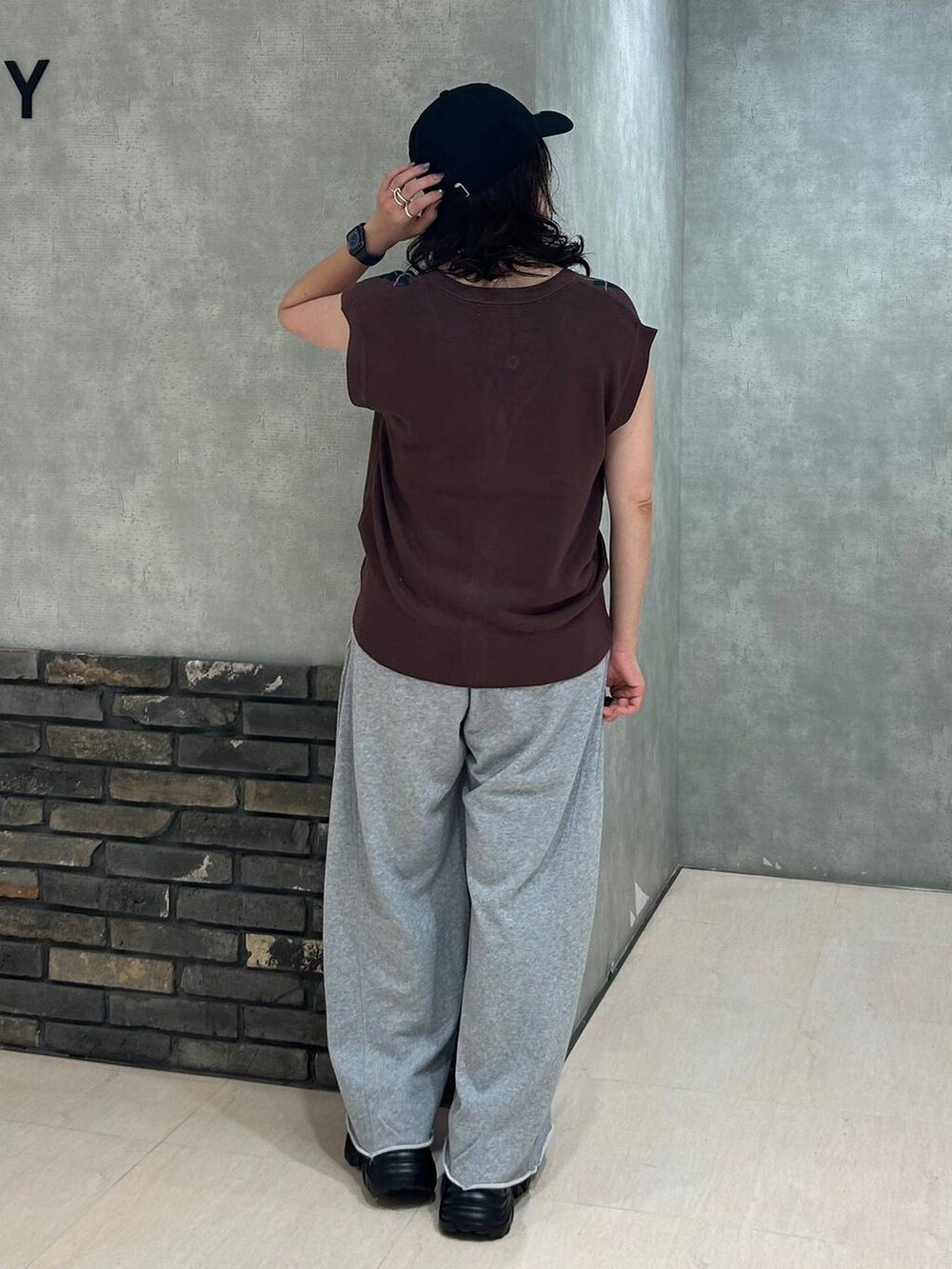 ブラック系のスニーカー、ブラック系のキャミソール、グレー系のスウェットパンツを着用したレディースの秋コーディネートの5枚目の写真