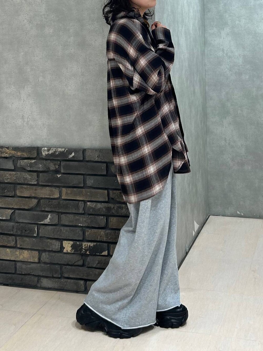 ブラック系のスニーカー、グレー系のスウェットパンツ、ブラウン系のシャツ/ブラウスを着用したレディースの秋コーディネートの6枚目の写真