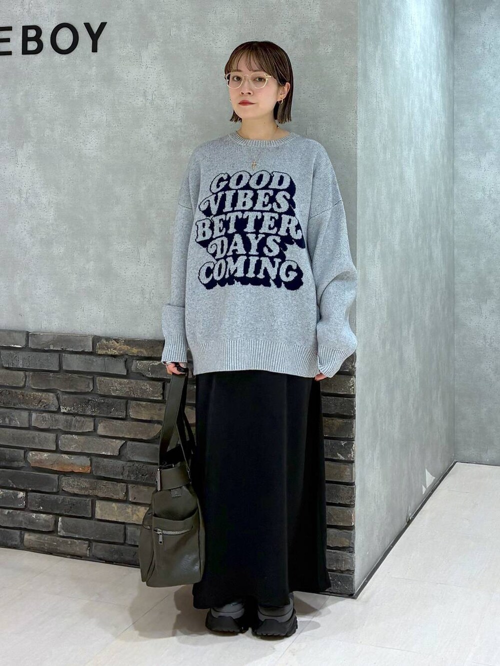 グレー系のスニーカー、グリーン系のボストンバッグ、グレー系のニット/セーターを着用したレディースの冬コーディネートの7枚目の写真