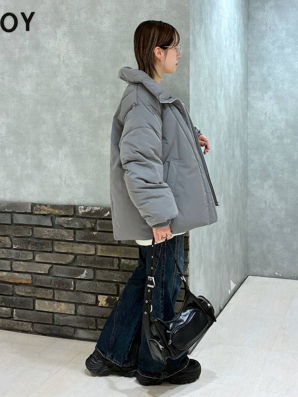 ブラック系のスニーカー、ブルー系のデニムパンツ、グレー系のブルゾンを着用したレディースの冬コーディネートの4枚目の写真