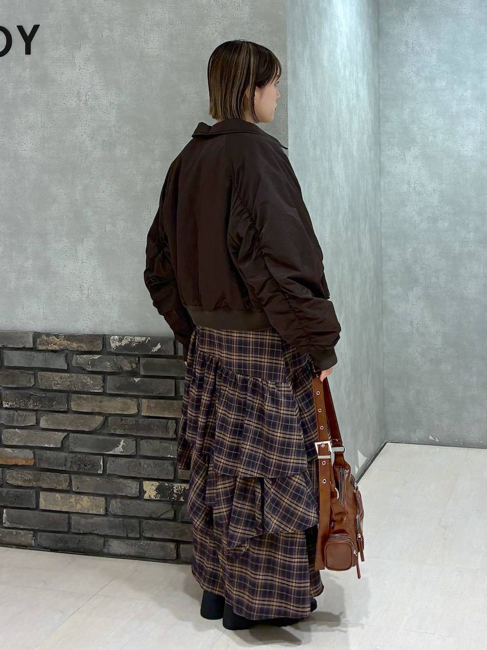 その他のブーツ、ブラウン系のスカート、ブラウン系のショルダーバッグを着用したレディースの冬コーディネートの5枚目の写真