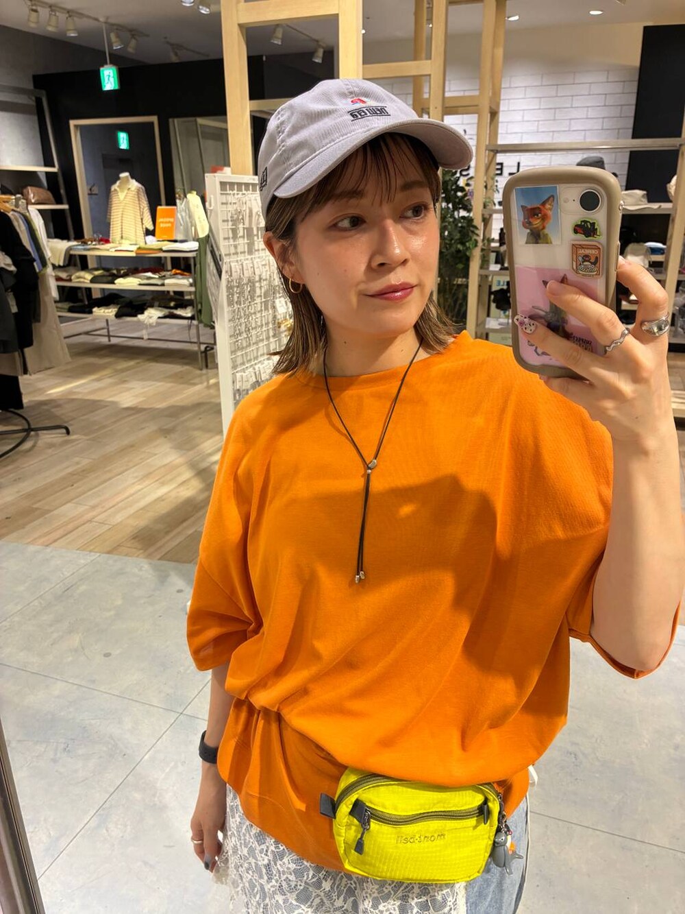 ブルー系のデニムパンツ、オレンジ系のTシャツ/カットソーを着用したレディースの春コーディネートの2枚目の写真