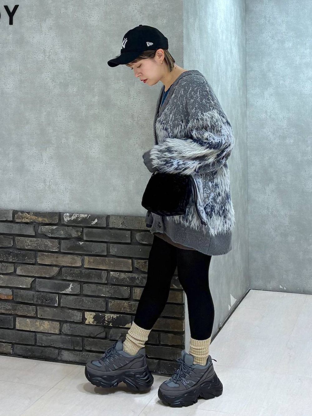 グレー系のスニーカー、グリーン系のニット/セーター、グレー系のカーディガン/ボレロを着用したレディースの冬コーディネートの3枚目の写真