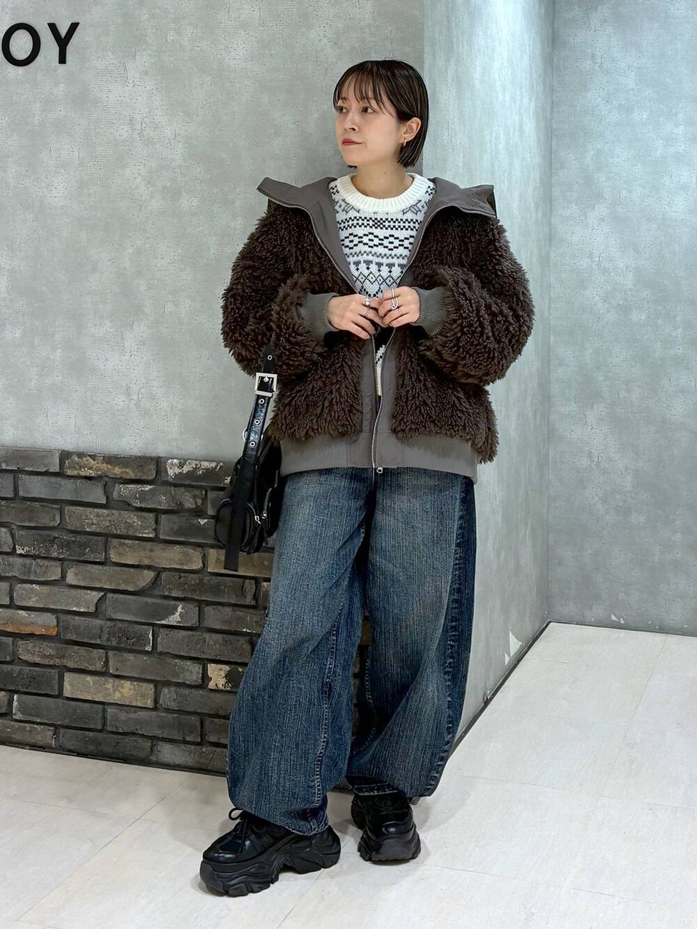 ブラック系のスニーカー、ブラウン系のブルゾン、ブラック系のショルダーバッグを着用したレディースの秋コーディネートの9枚目の写真