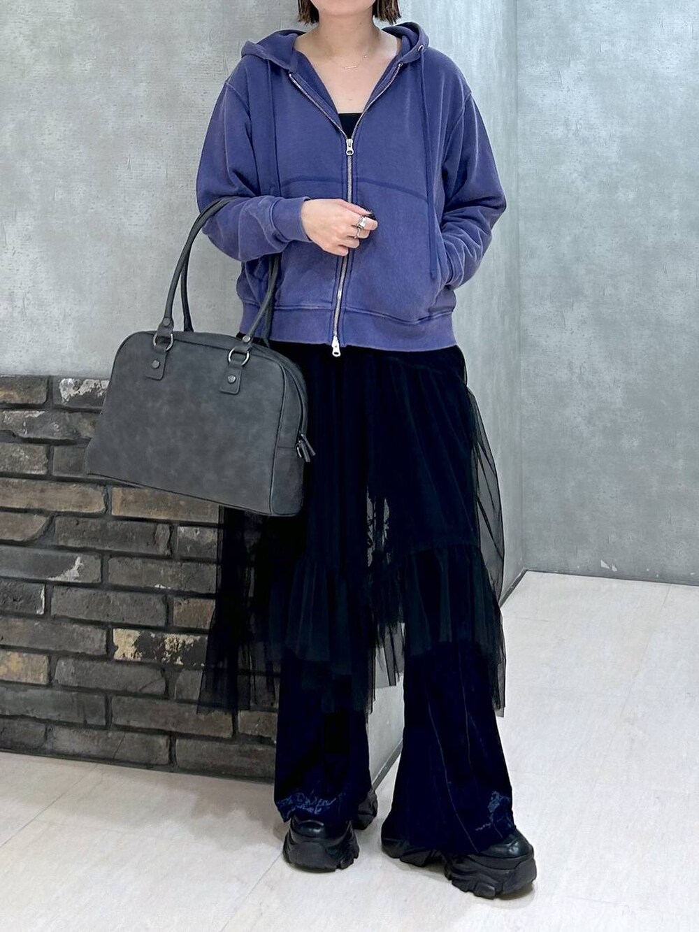 ブラック系のスニーカー、グレー系のボストンバッグ、ブラック系のキャミソールを着用したレディースの秋コーディネートの7枚目の写真