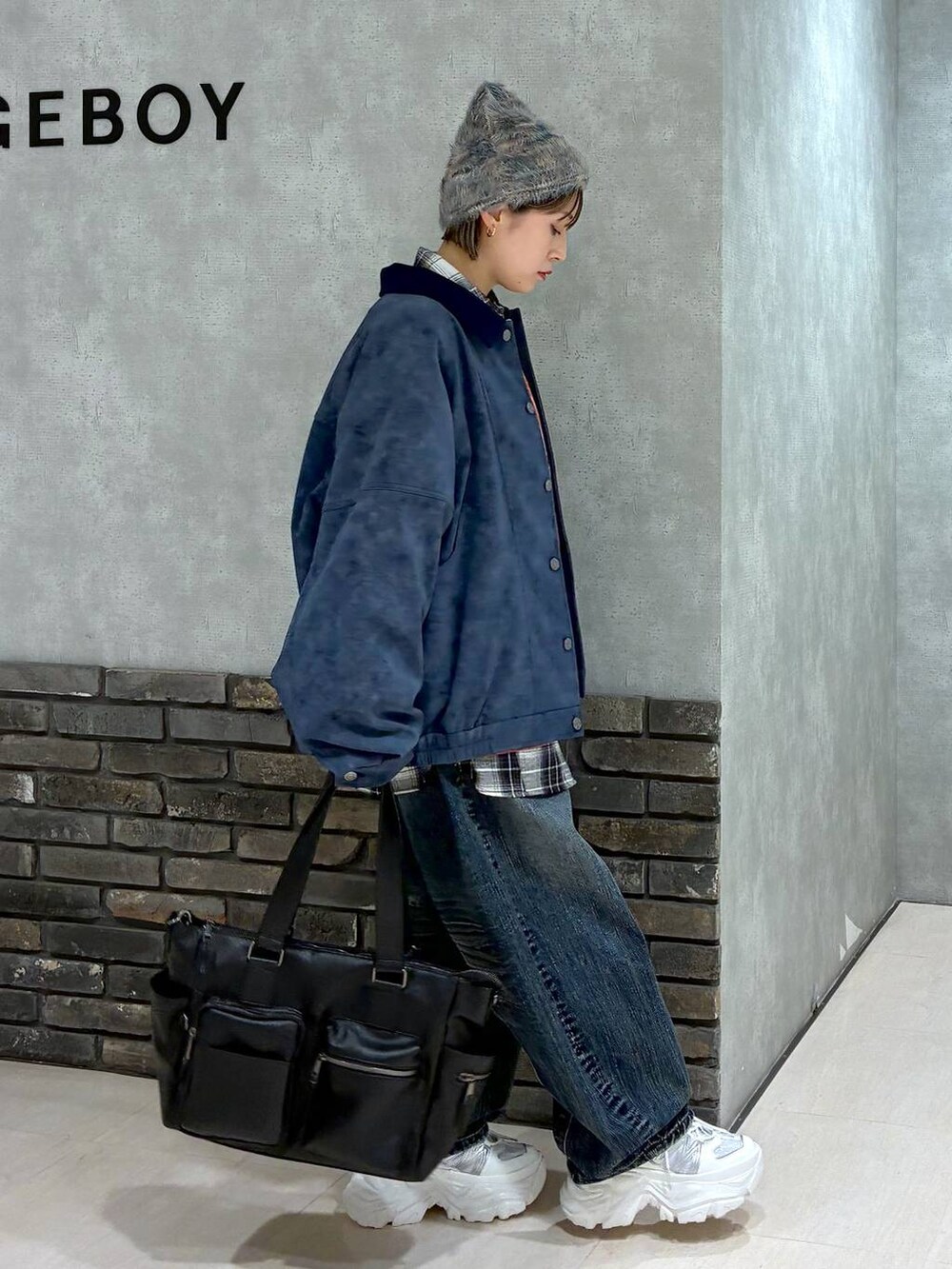 ホワイト系のスニーカー、ブラック系のボストンバッグ、レッド系のスウェットを着用したレディースの冬コーディネートの3枚目の写真