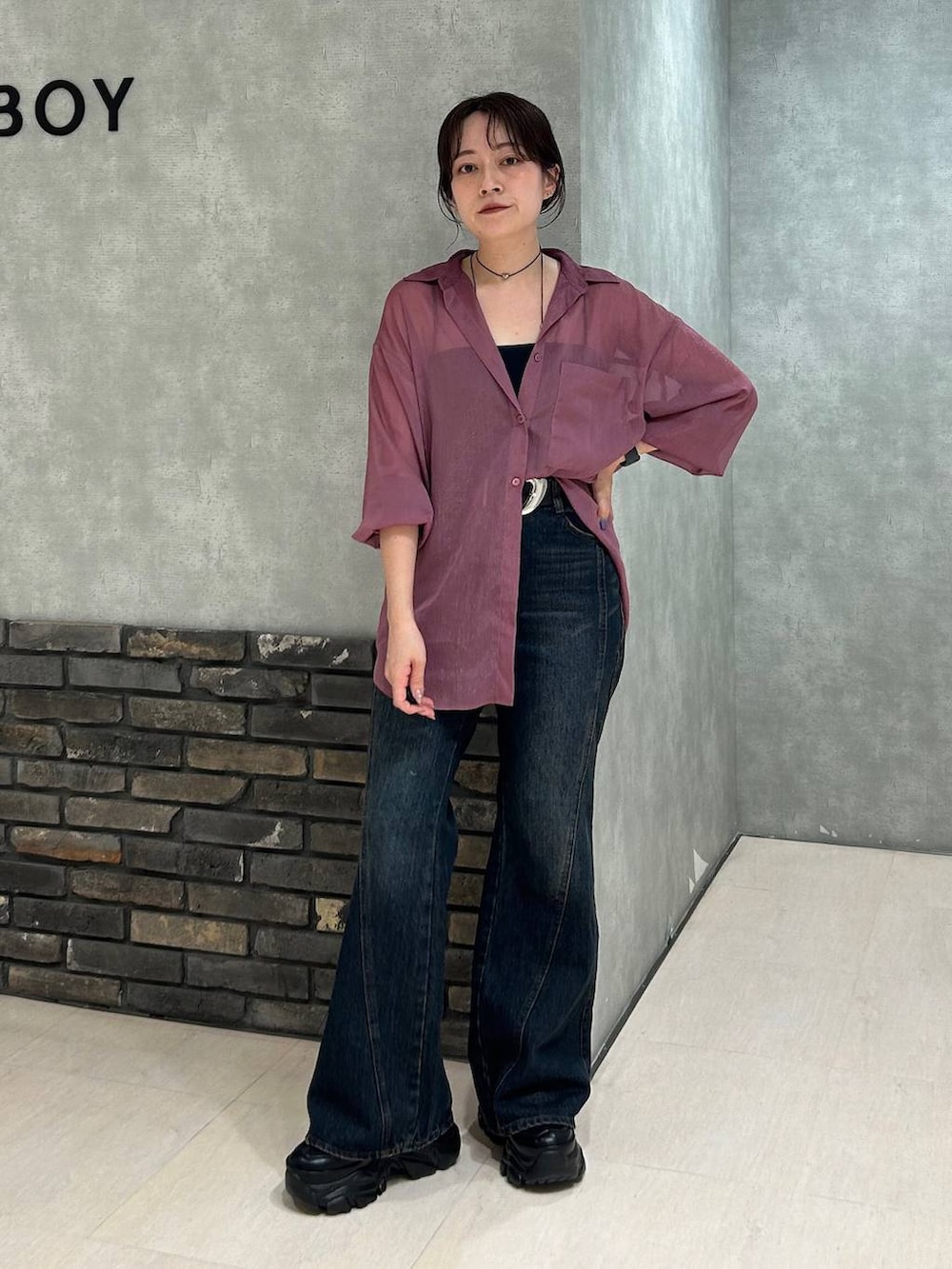 ブラック系のスニーカー、レッド系のシャツ/ブラウス、ブルー系のデニムパンツを着用したレディースの夏コーディネートの2枚目の写真