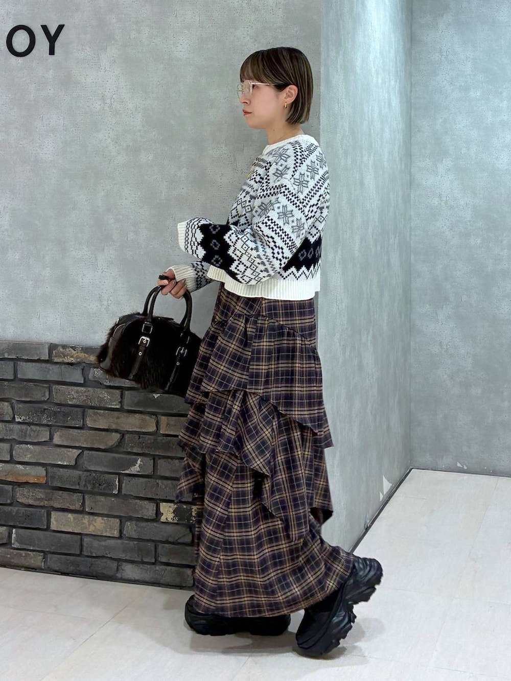 ブラック系のブーツ、ブラウン系のスカート、ブラウン系のボストンバッグを着用したレディースの冬コーディネートの6枚目の写真