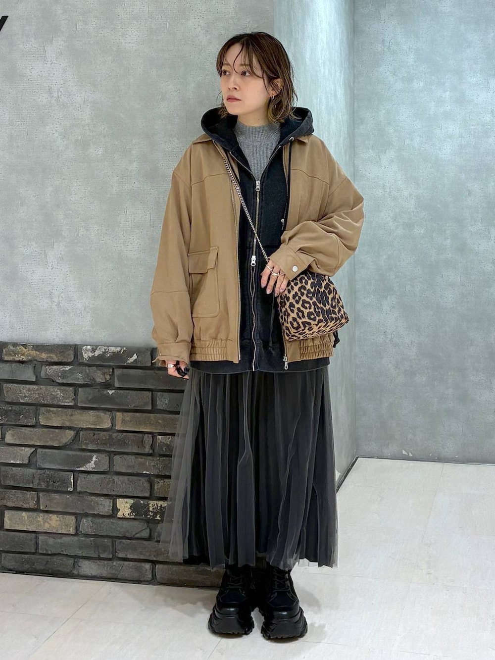 ブラック系のブーツ、イエロー系のブルゾン、ブラック系のパーカーを着用したレディースの秋コーディネートの6枚目の写真