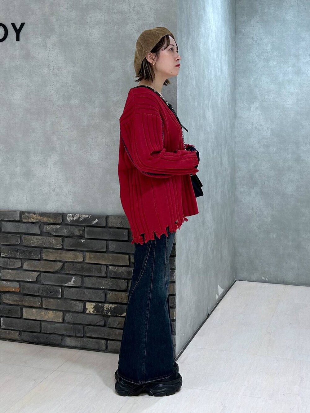 ブラック系のスニーカー、ブルー系のデニムパンツ、その他のハンドバッグを着用したレディースの秋コーディネートの3枚目の写真