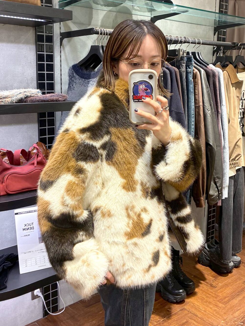 ブラック系のスニーカー、ブルー系のデニムパンツ、ブラウン系のブルゾンを着用したレディースの秋コーディネートの5枚目の写真