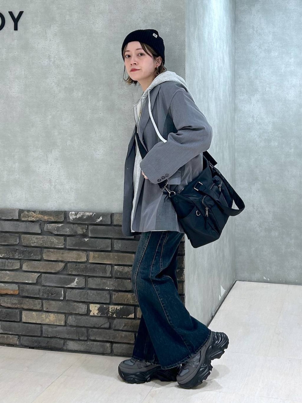 グレー系のスニーカー、ブルー系のデニムパンツ、グレー系のテーラードジャケットを着用したレディースの秋コーディネートの7枚目の写真