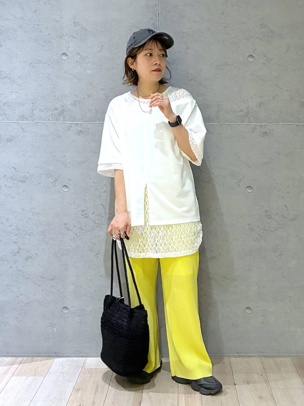 イエロー系のその他パンツ、ブラック系のショルダーバッグ、ホワイト系のTシャツ/カットソーを着用したレディースの春コーディネートの2枚目の写真