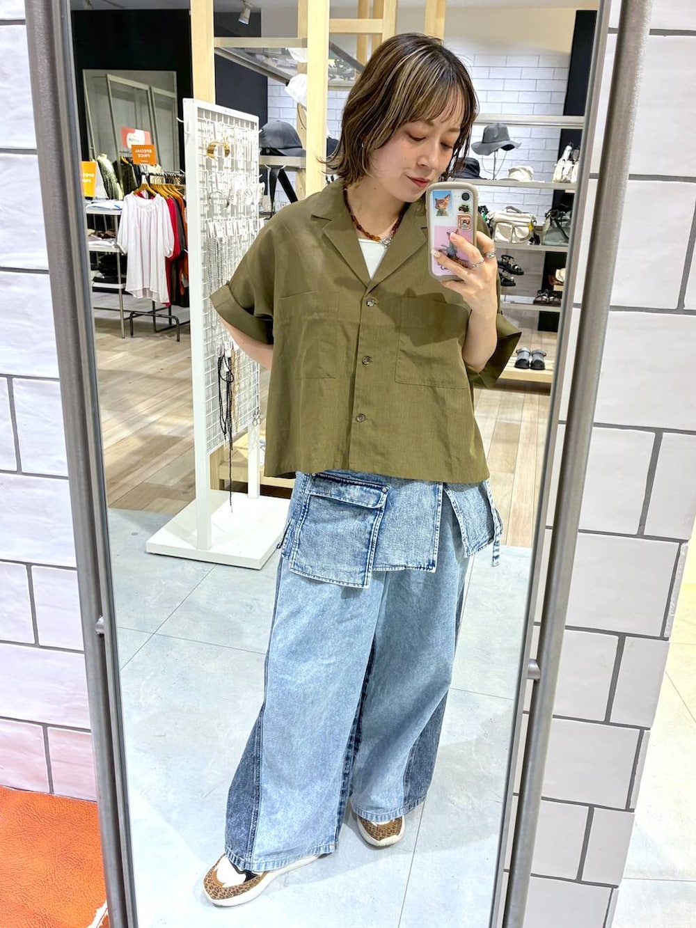 ブルー系のデニムパンツ、ブルー系のベルト、イエロー系のネックレスを着用したレディースの春コーディネートの2枚目の写真