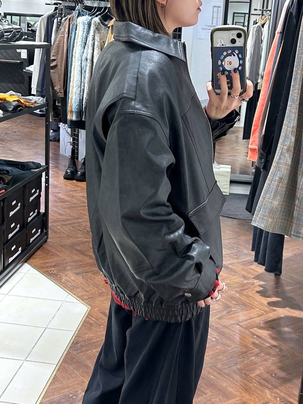 ブラック系のスニーカー、ブラック系のスウェットパンツ、ブラック系のブルゾンを着用したレディースの秋コーディネートの4枚目の写真