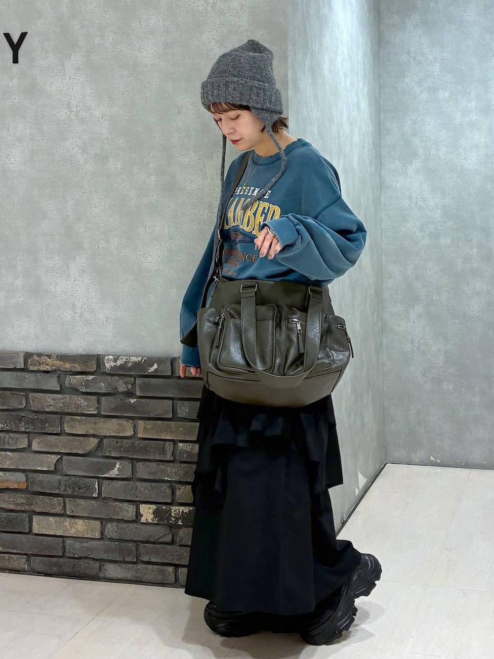 ブラック系のスニーカー、グリーン系のボストンバッグ、グリーン系のスウェットを着用したレディースの冬コーディネートの6枚目の写真