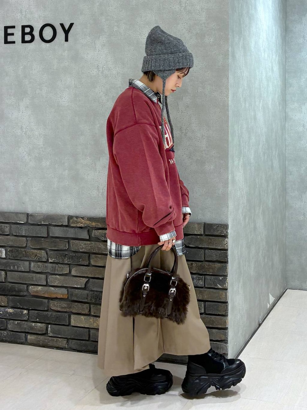 ブラック系のブーツ、レッド系のスウェット、ブルー系のシャツ/ブラウスを着用したレディースの秋コーディネートの3枚目の写真