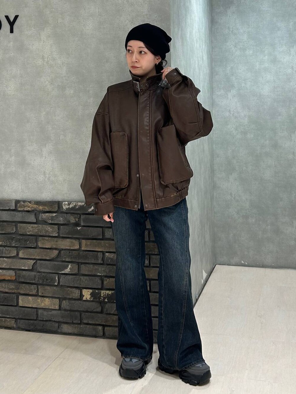 グレー系のスニーカー、ブルー系のデニムパンツ、ブラック系のTシャツ/カットソーを着用したレディースの秋コーディネートの8枚目の写真