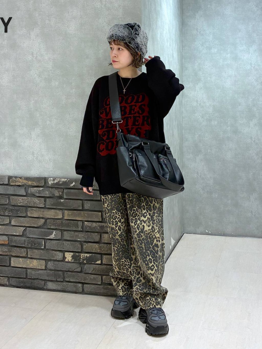 グレー系のスニーカー、ブラック系のボストンバッグ、ブラック系のニット/セーターを着用したレディースの冬コーディネートの7枚目の写真