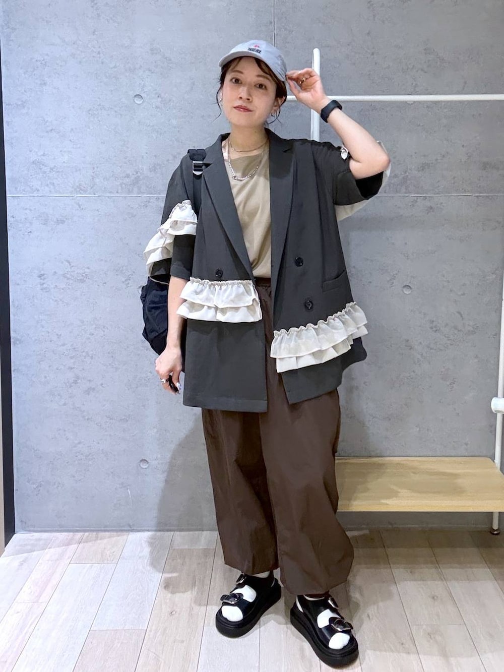ベージュ系のTシャツ/カットソー、ブラック系のサンダル、ブラック系のバックパック/リュックを着用したレディースの春コーディネートの2枚目の写真