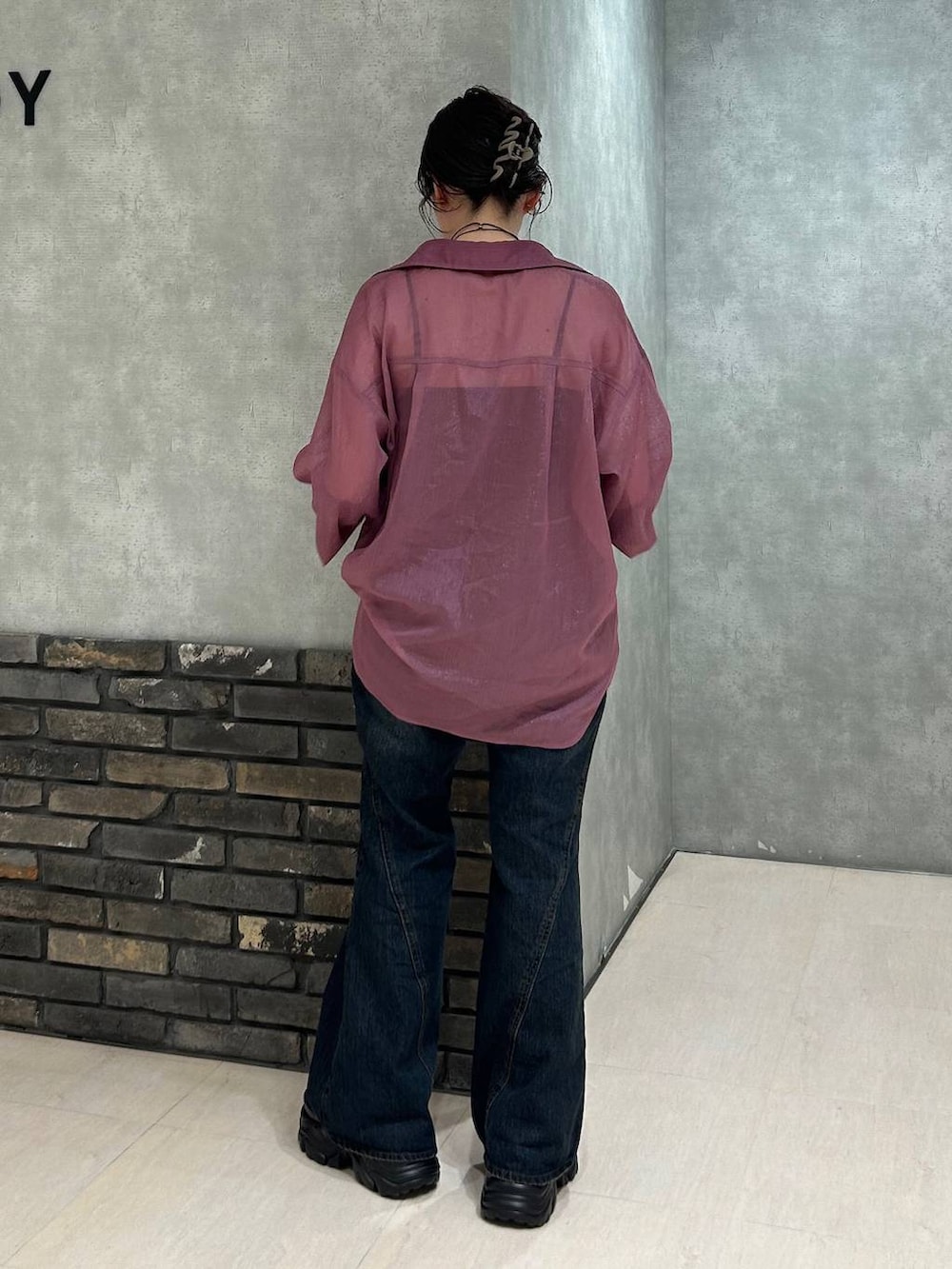 ブラック系のスニーカー、レッド系のシャツ/ブラウス、ブルー系のデニムパンツを着用したレディースの夏コーディネートの5枚目の写真