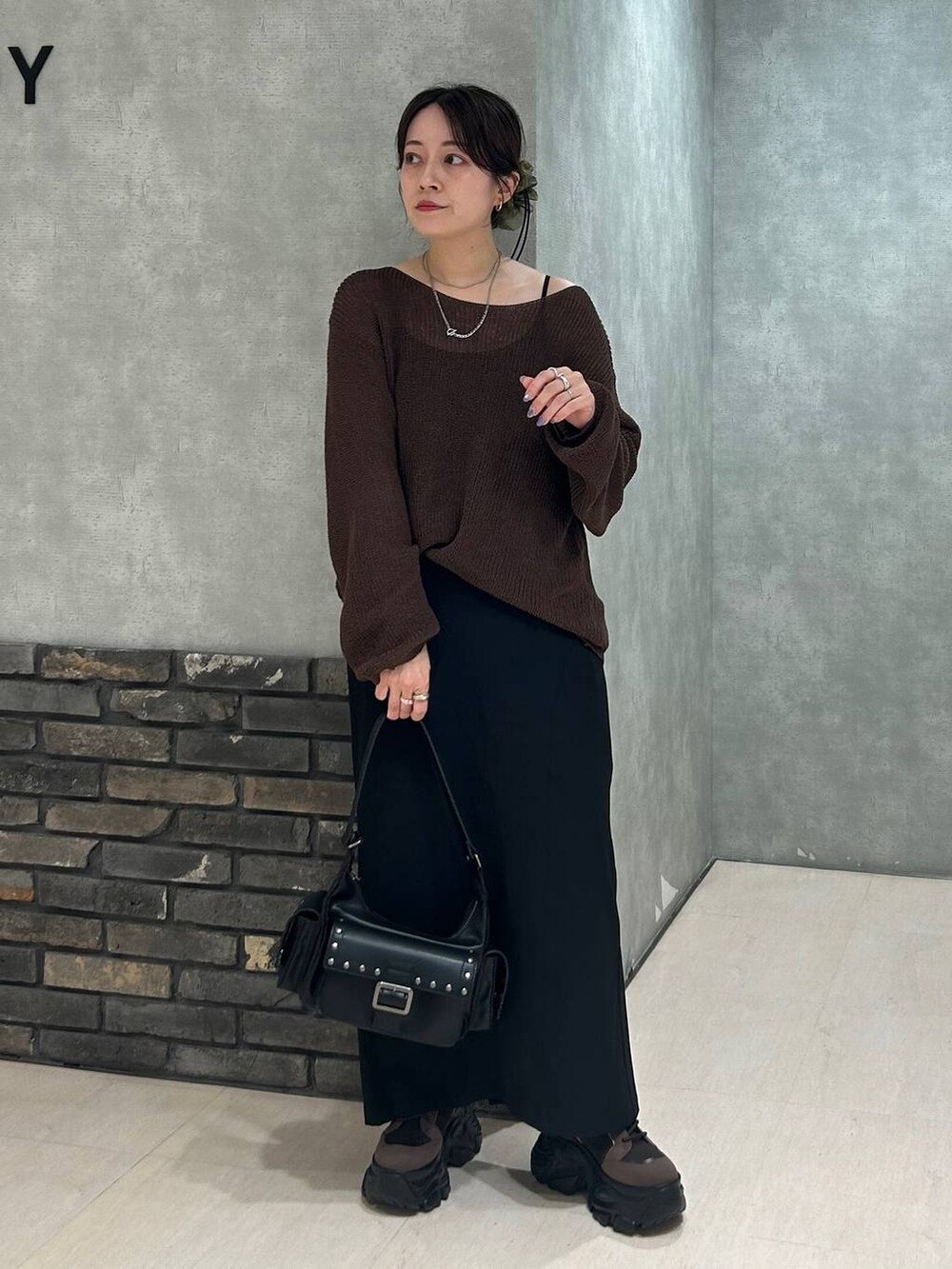 ブラウン系のブーツ、ブラック系のキャミソール、ブラウン系のニット/セーターを着用したレディースの秋コーディネートの8枚目の写真