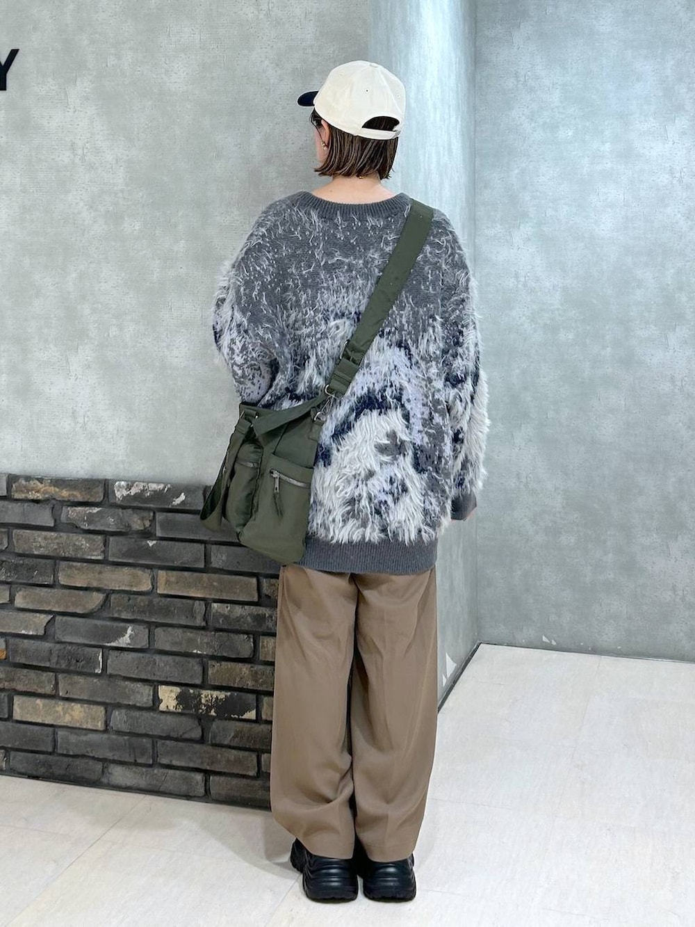 ブラック系のスニーカー、グリーン系のボストンバッグ、グレー系のカーディガン/ボレロを着用したレディースの秋コーディネートの5枚目の写真