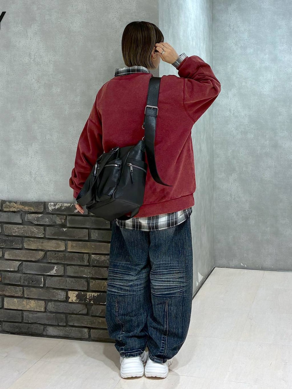 ホワイト系のスニーカー、ブラック系のボストンバッグ、レッド系のスウェットを着用したレディースの冬コーディネートの3枚目の写真