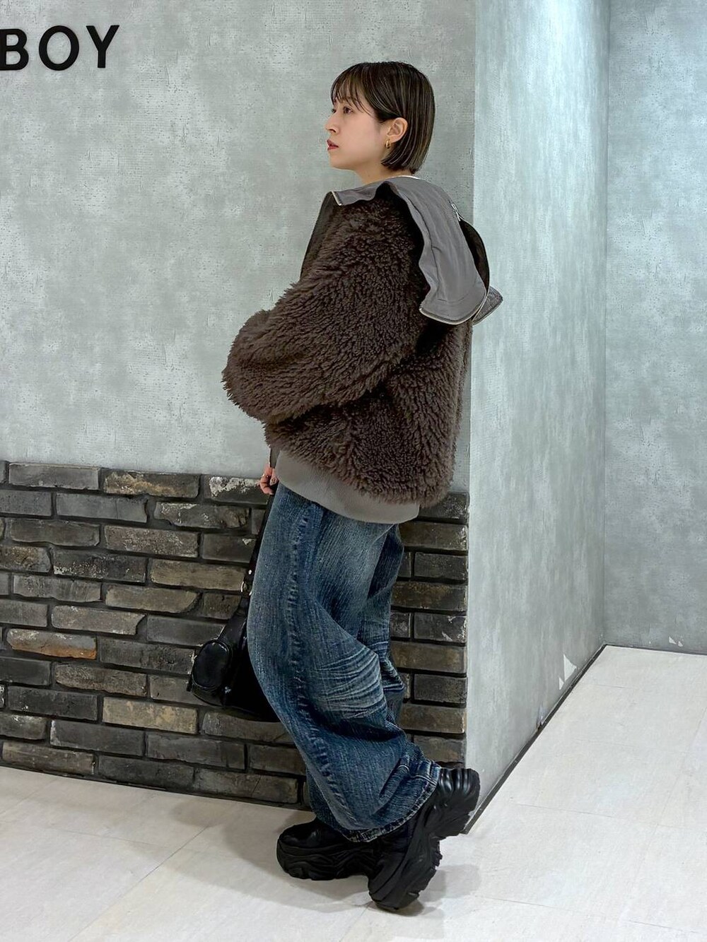 ブラック系のスニーカー、ブラウン系のブルゾン、ブラック系のショルダーバッグを着用したレディースの秋コーディネートの7枚目の写真