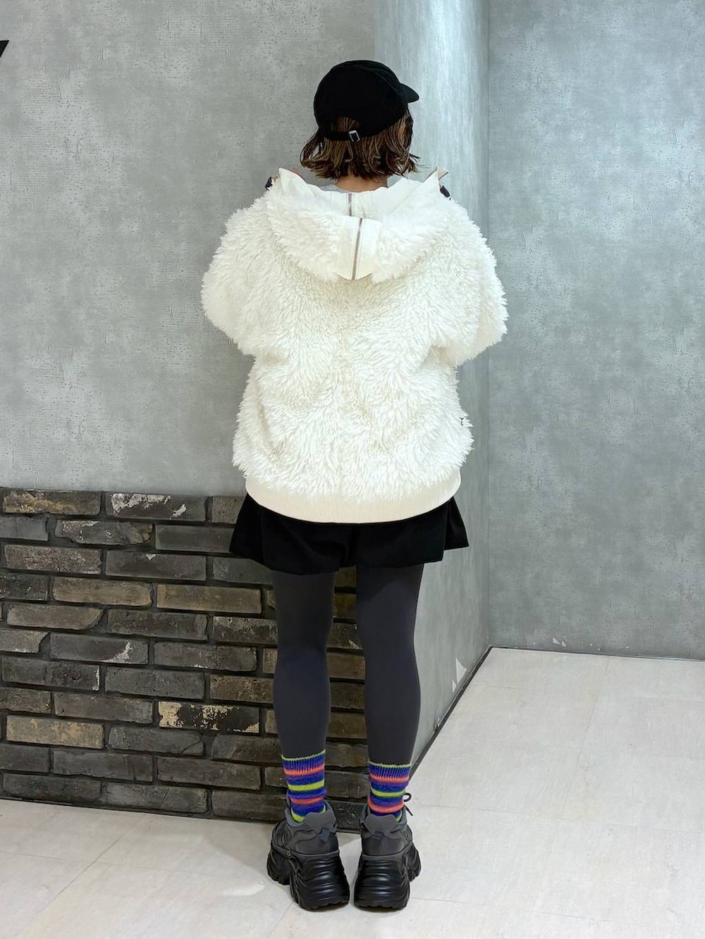 グレー系のスニーカー、ホワイト系のブルゾン、ブラック系のその他パンツを着用したレディースの冬コーディネートの5枚目の写真