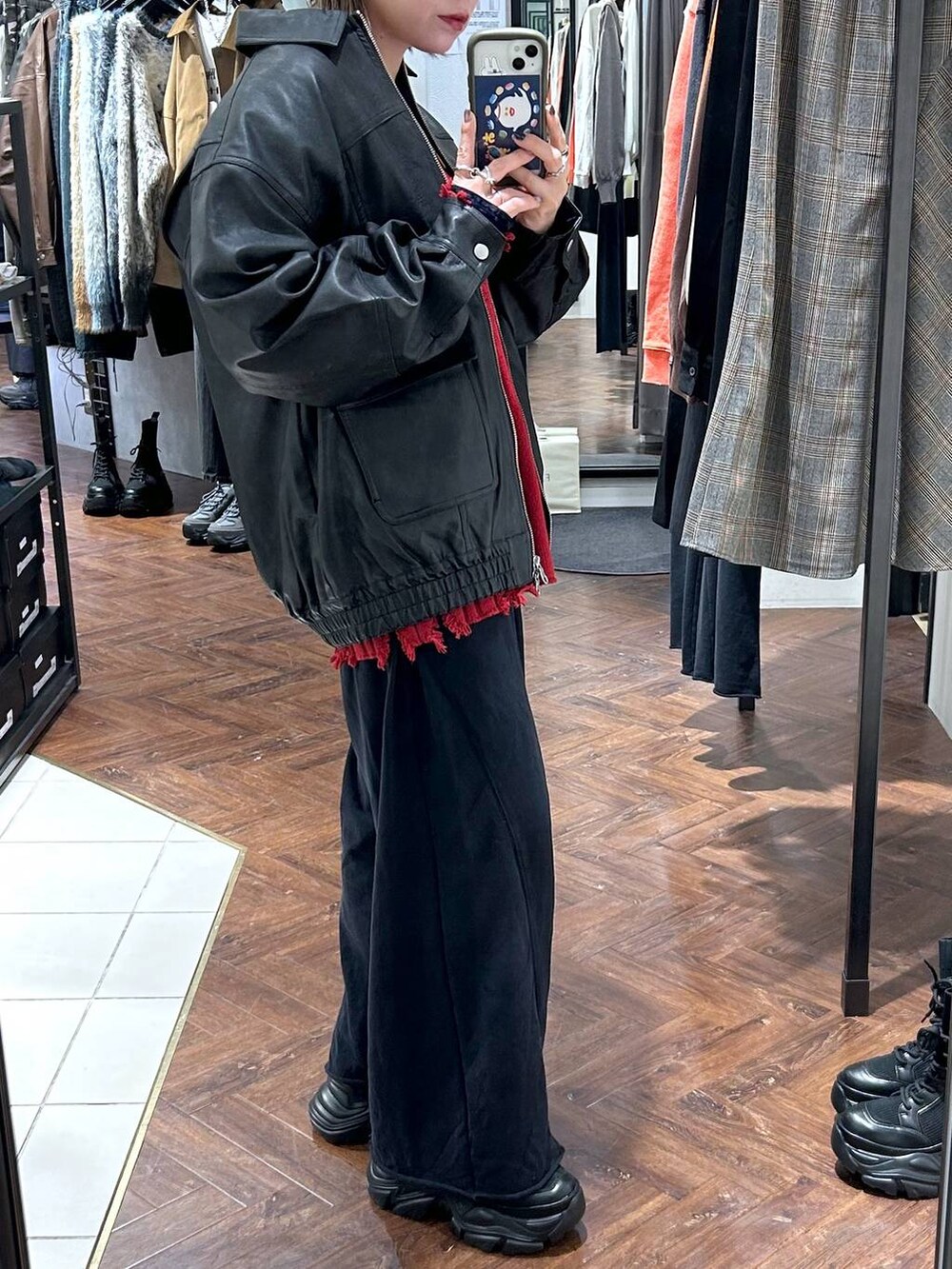 ブラック系のスニーカー、ブラック系のスウェットパンツ、ブラック系のブルゾンを着用したレディースの秋コーディネートの3枚目の写真