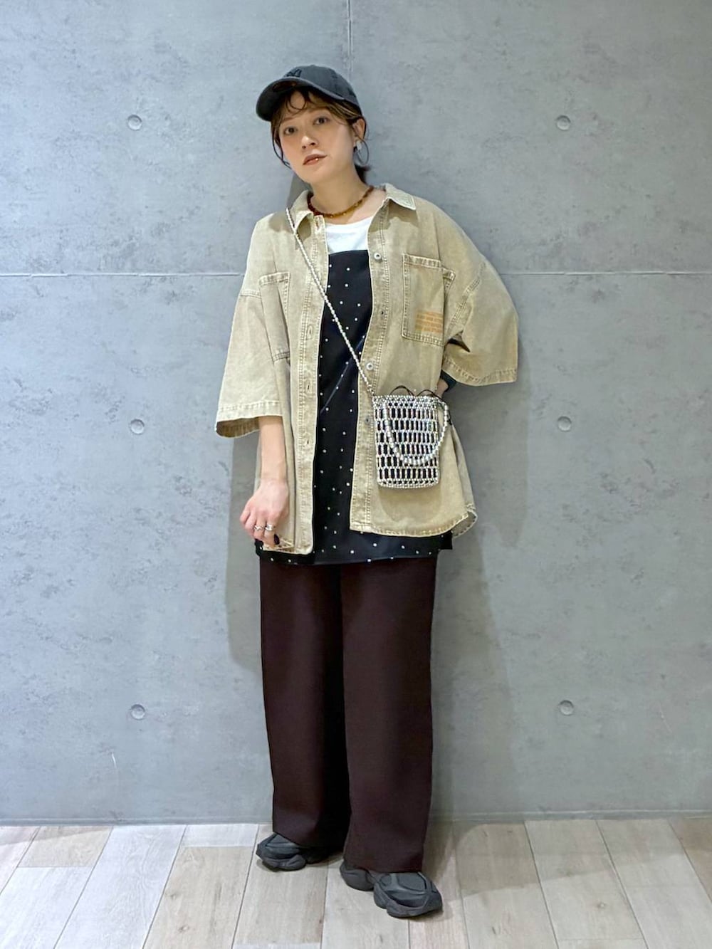 ブラウン系のその他パンツ、ベージュ系のシャツ/ブラウス、シルバー系のショルダーバッグを着用したレディースの春コーディネートの2枚目の写真