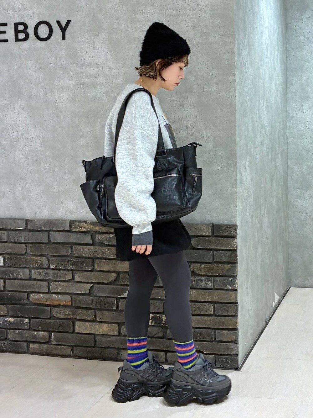 グレー系のスニーカー、ブラック系のボストンバッグ、ブラック系のその他パンツを着用したレディースの冬コーディネートの2枚目の写真