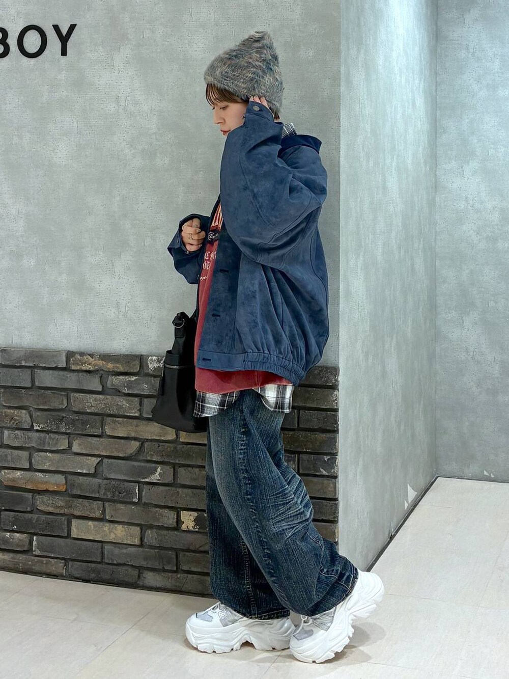 ホワイト系のスニーカー、ブラック系のボストンバッグ、レッド系のスウェットを着用したレディースの冬コーディネートの7枚目の写真