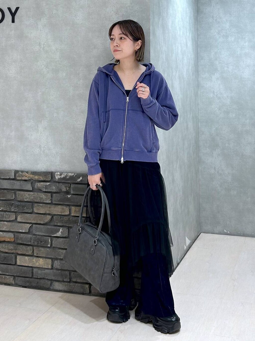 ブラック系のスニーカー、グレー系のボストンバッグ、ブラック系のキャミソールを着用したレディースの秋コーディネートの2枚目の写真