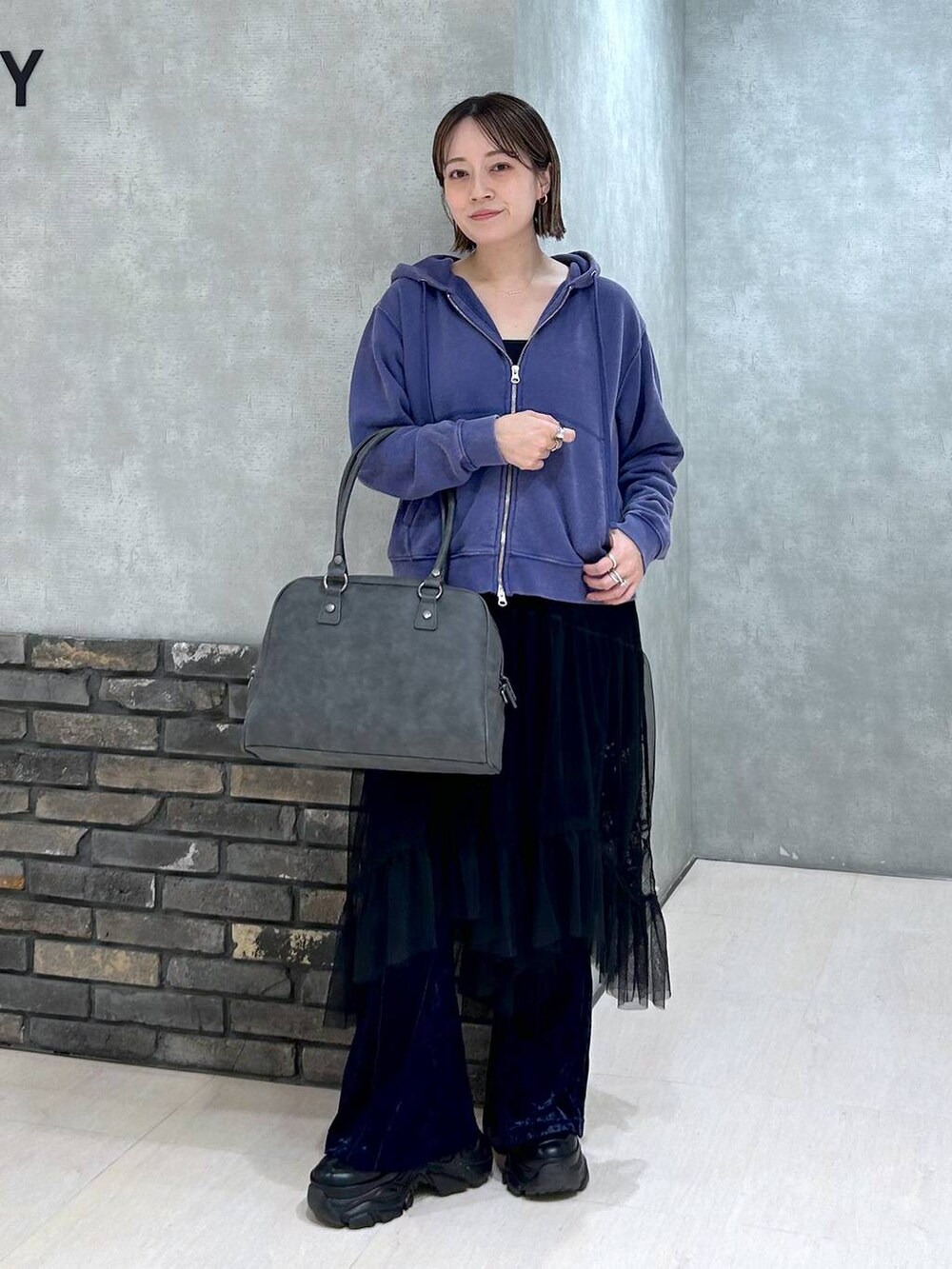 ブラック系のスニーカー、グレー系のボストンバッグ、ブラック系のキャミソールを着用したレディースの秋コーディネートの6枚目の写真