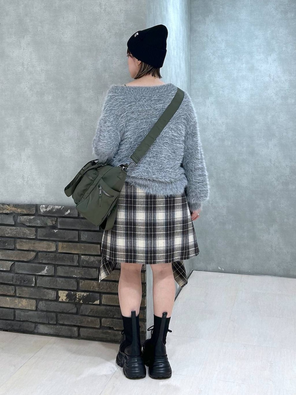 ブラック系のブーツ、グリーン系のボストンバッグ、ブラック系のその他パンツを着用したレディースの秋コーディネートの4枚目の写真