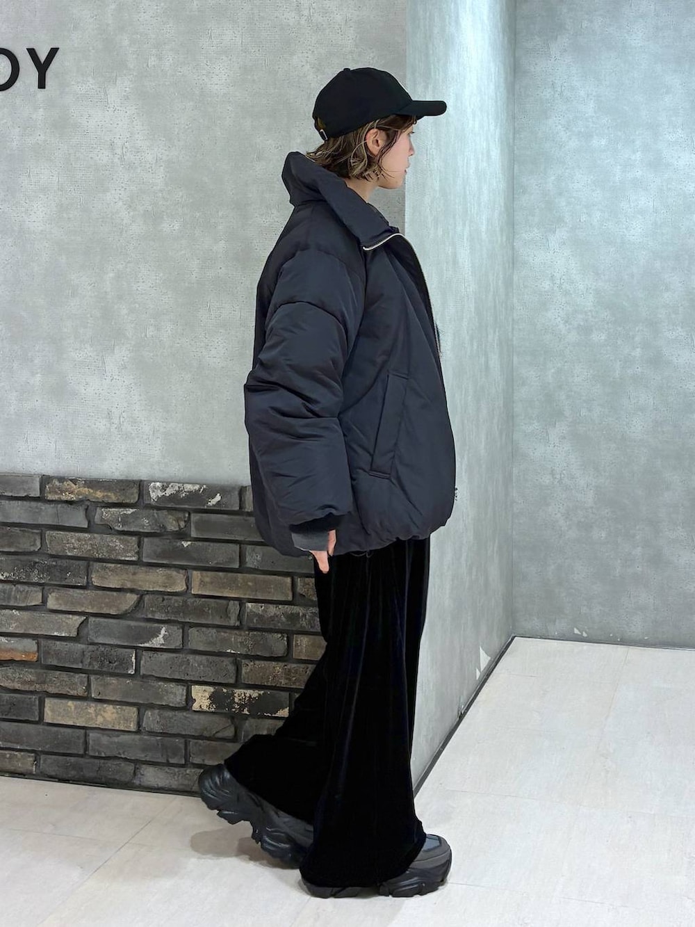 グレー系のスニーカー、ブラック系のブルゾン、ブラック系のその他パンツを着用したレディースの冬コーディネートの2枚目の写真