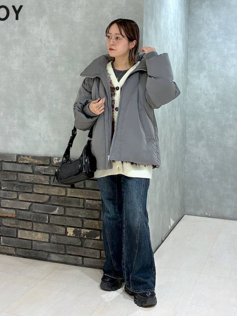 ブラック系のスニーカー、ブルー系のデニムパンツ、グレー系のブルゾンを着用したレディースの冬コーディネートの8枚目の写真