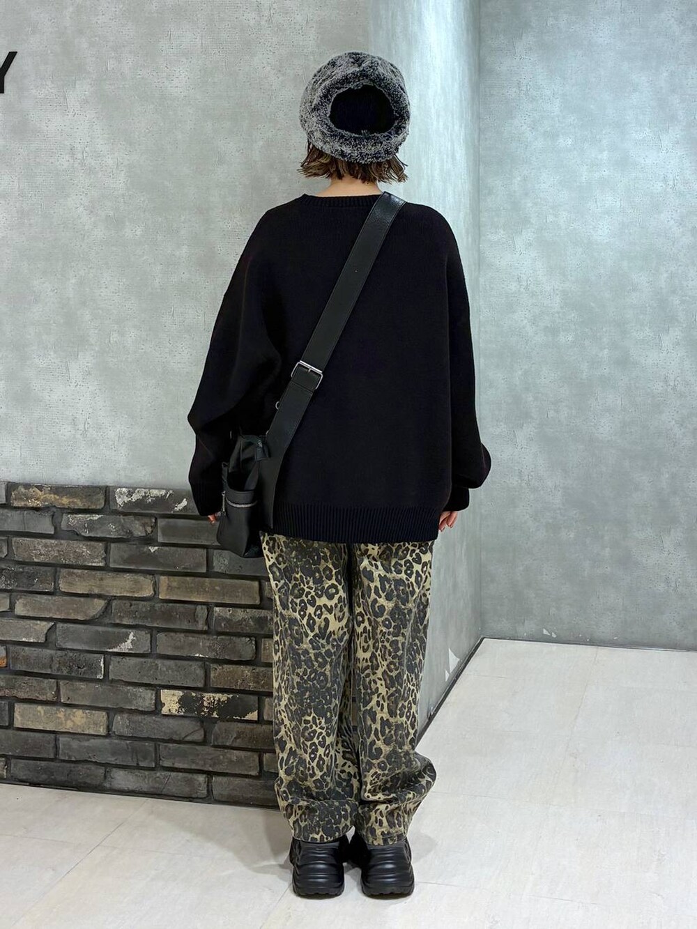 グレー系のスニーカー、ブラック系のボストンバッグ、ブラック系のニット/セーターを着用したレディースの冬コーディネートの4枚目の写真