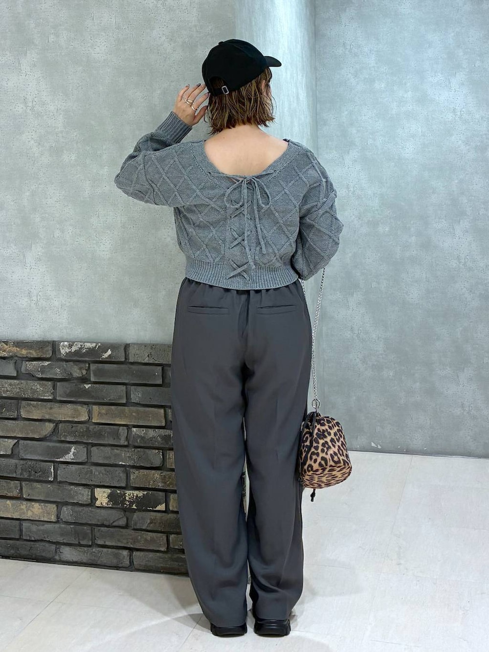 グレー系のスラックス、グレー系のニット/セーター、その他のハンドバッグを着用したレディースの秋コーディネートの4枚目の写真