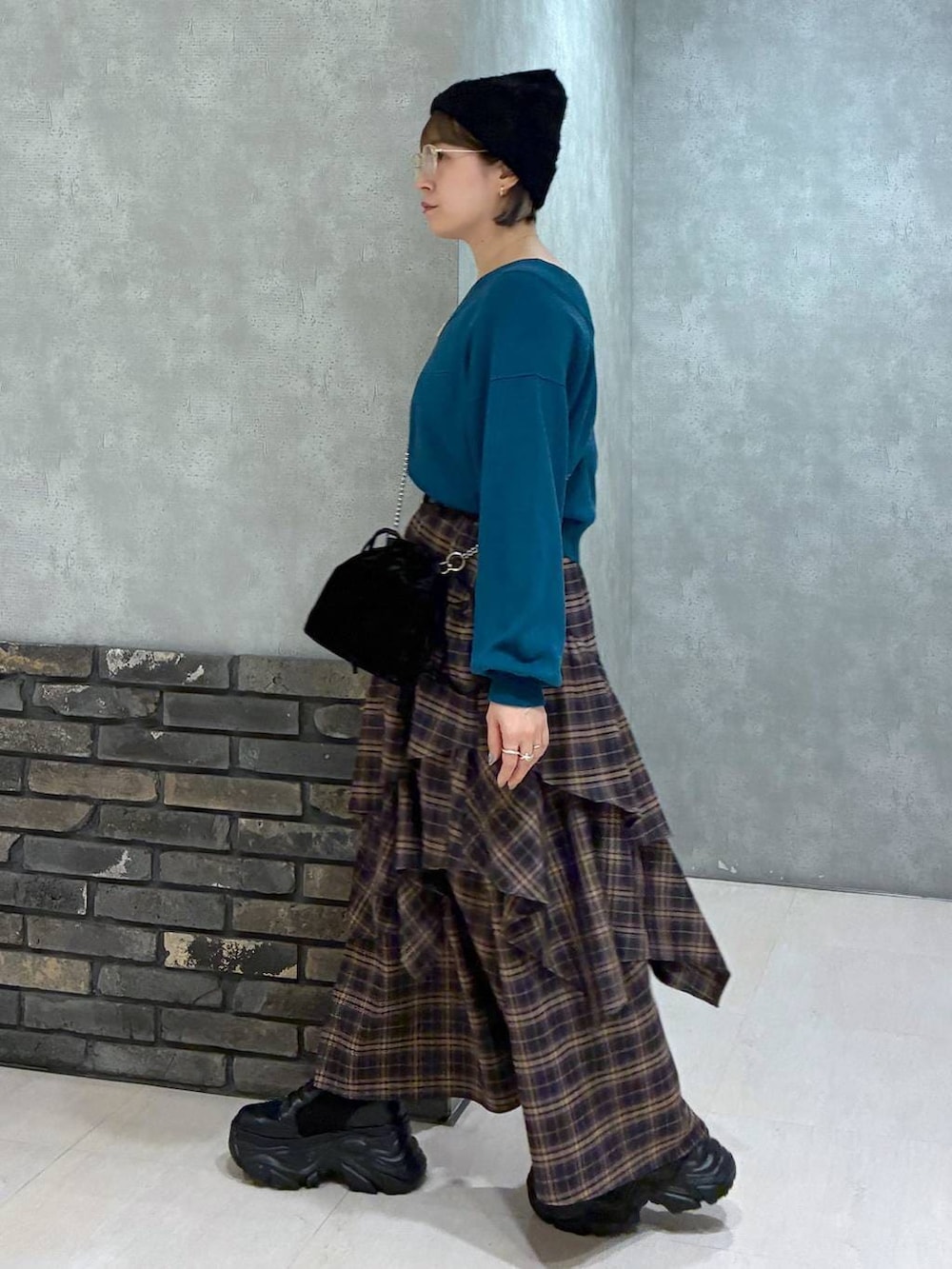 ブラック系のブーツ、ブラウン系のスカート、グリーン系のニット/セーターを着用したレディースの冬コーディネートの4枚目の写真